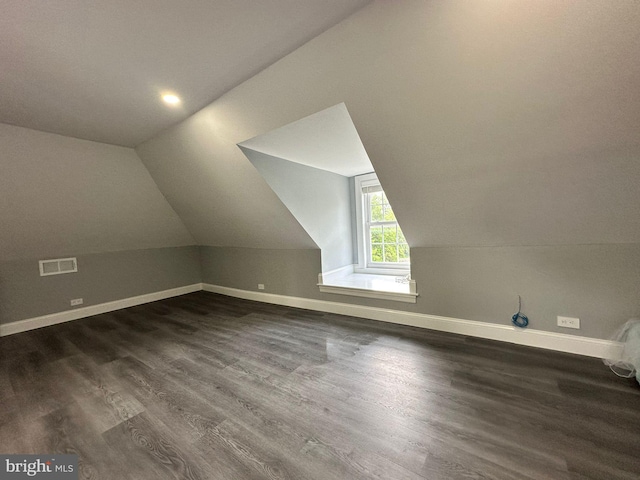 additional living space with vaulted ceiling and dark wood-type flooring