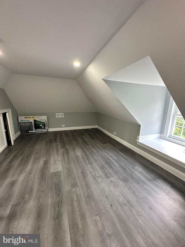 additional living space with dark hardwood / wood-style floors and vaulted ceiling