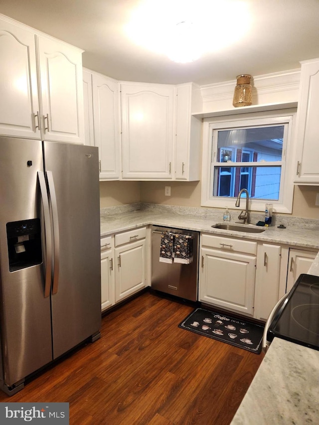 kitchen with appliances with stainless steel finishes, white cabinets, a sink, and light countertops