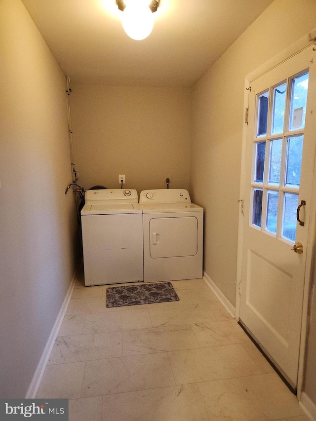 washroom featuring laundry area, baseboards, marble finish floor, and washing machine and clothes dryer