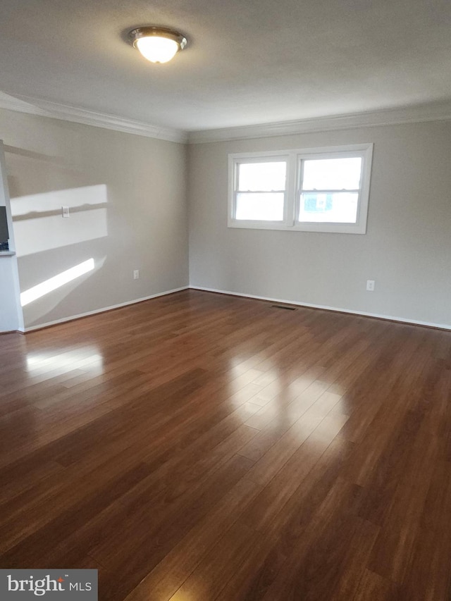 empty room with crown molding and dark wood-type flooring