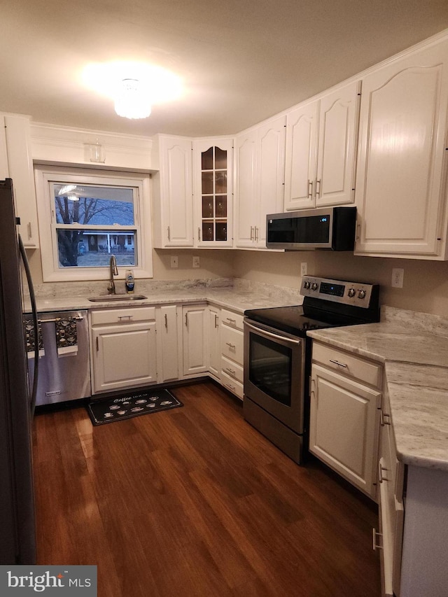 kitchen with sink, white cabinetry, dark wood-type flooring, and appliances with stainless steel finishes