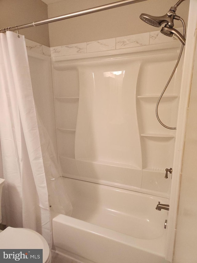 bathroom with toilet and shower / bath combo with shower curtain