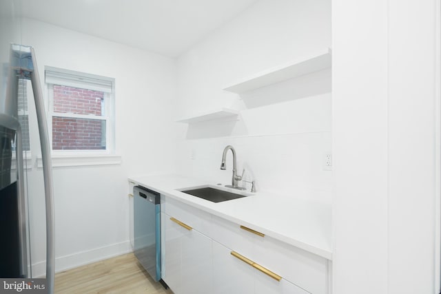 kitchen with decorative backsplash, white cabinets, stainless steel dishwasher, light hardwood / wood-style flooring, and sink