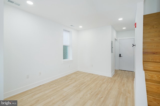 unfurnished room featuring light wood-type flooring and electric panel