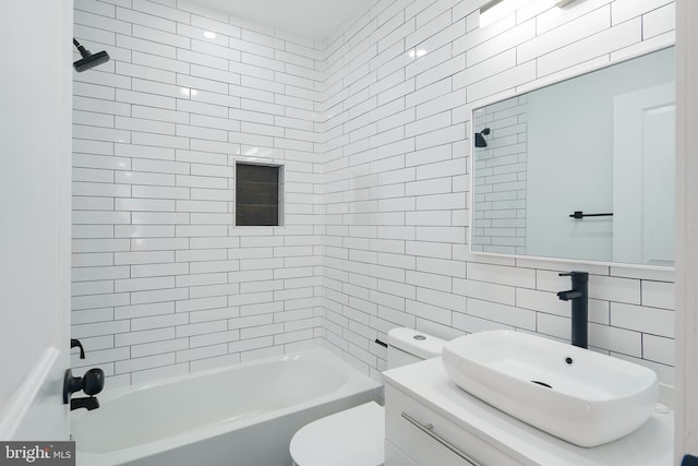 full bathroom with tiled shower / bath, vanity, backsplash, toilet, and tile walls