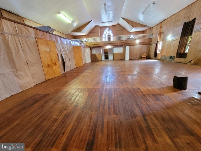 bonus room featuring wooden walls, wood-type flooring, and lofted ceiling