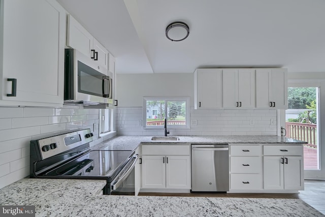 kitchen featuring tasteful backsplash, appliances with stainless steel finishes, sink, and white cabinets