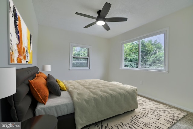 bedroom with multiple windows, ceiling fan, and carpet flooring