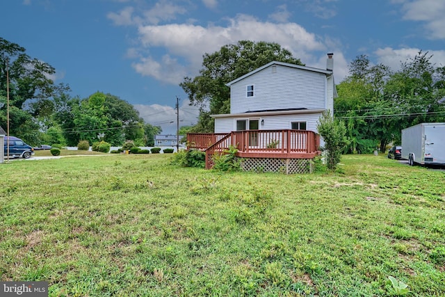 rear view of property featuring a yard and a deck