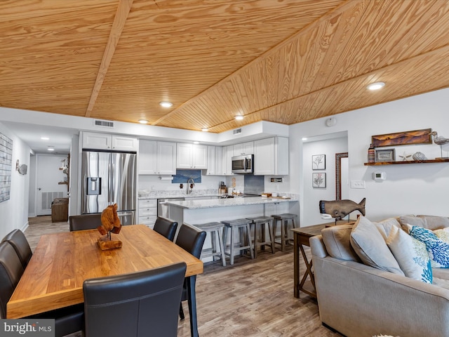 dining room with wooden ceiling, light hardwood / wood-style flooring, and sink