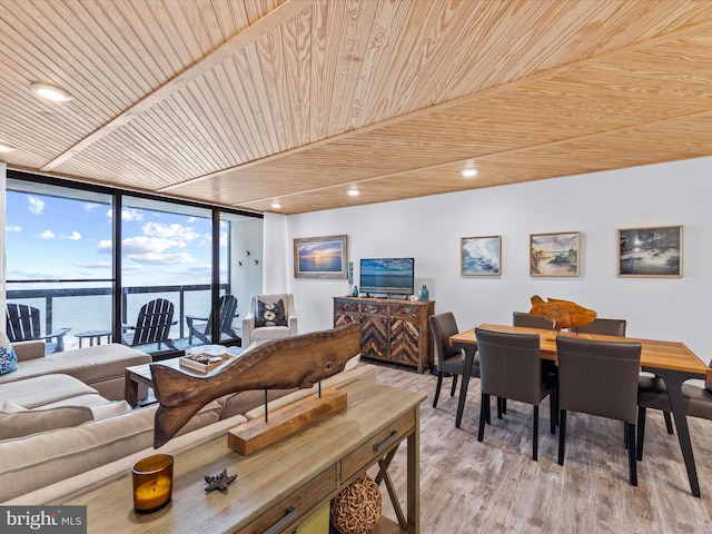 dining space featuring wood ceiling, a water view, expansive windows, and light hardwood / wood-style floors