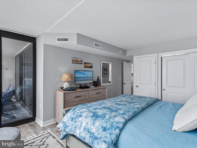 bedroom with a textured ceiling, a closet, and light wood-type flooring