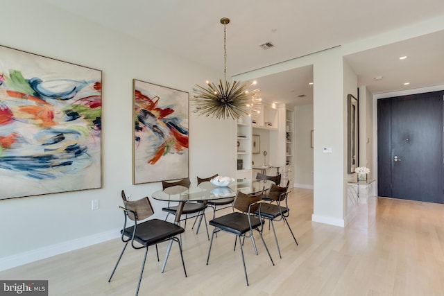 dining space featuring light hardwood / wood-style floors, built in features, and a notable chandelier