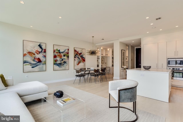 living room featuring light hardwood / wood-style flooring and a notable chandelier