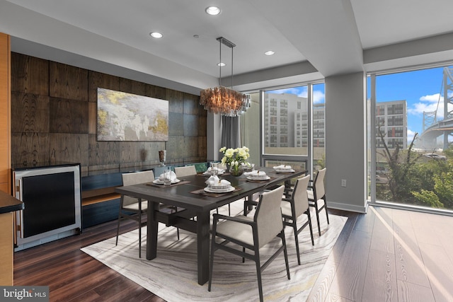 dining area featuring a notable chandelier, dark wood-type flooring, and wine cooler