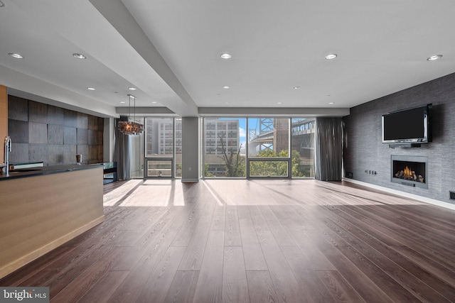 unfurnished living room featuring hardwood / wood-style flooring and sink