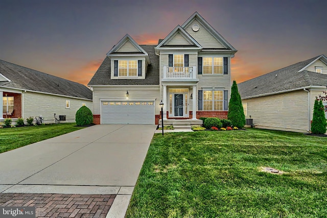 view of front of property featuring a lawn, a balcony, and a garage