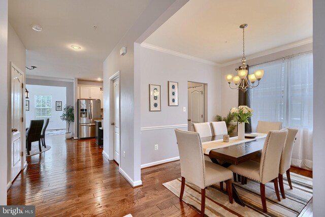 dining area featuring ornamental molding, dark hardwood / wood-style floors, and a chandelier