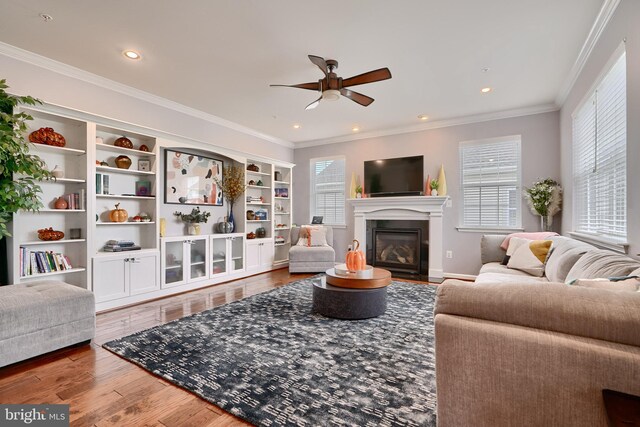 living room featuring ceiling fan, ornamental molding, and hardwood / wood-style floors