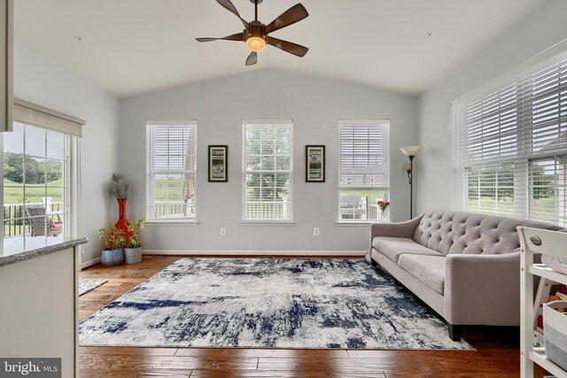 living room featuring light hardwood / wood-style floors, lofted ceiling, and ceiling fan