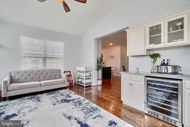 living room with wine cooler, lofted ceiling, ceiling fan, indoor bar, and dark hardwood / wood-style floors