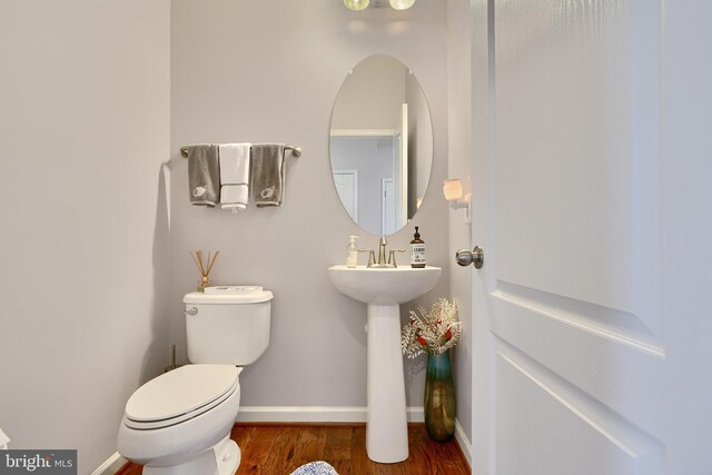 bathroom featuring wood-type flooring and toilet