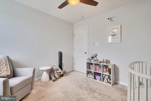 interior space with a crib and ceiling fan