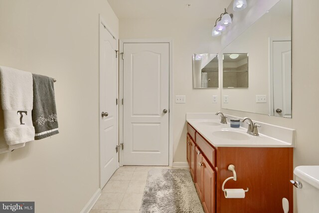 bathroom featuring tile patterned flooring, vanity, and toilet