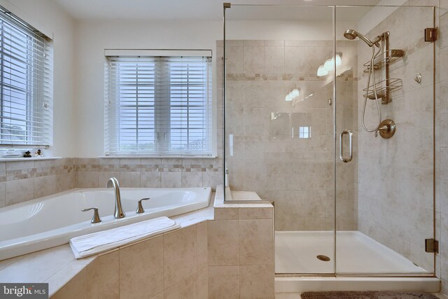 bathroom featuring separate shower and tub