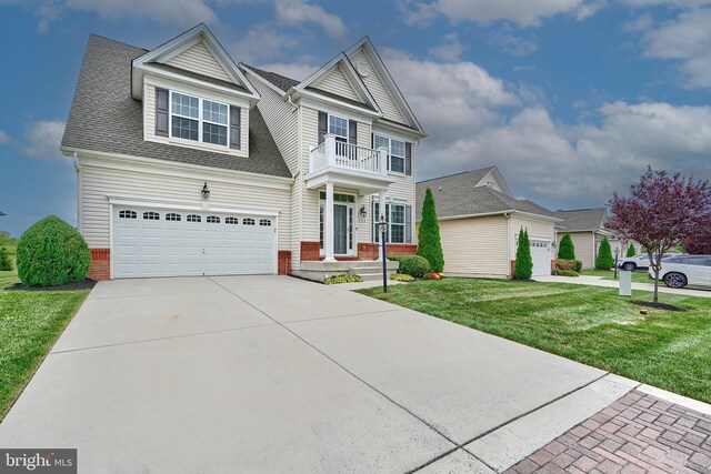 view of front facade featuring a front yard, a balcony, and a garage