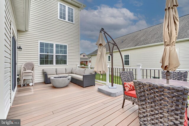 wooden deck featuring an outdoor living space with a fire pit