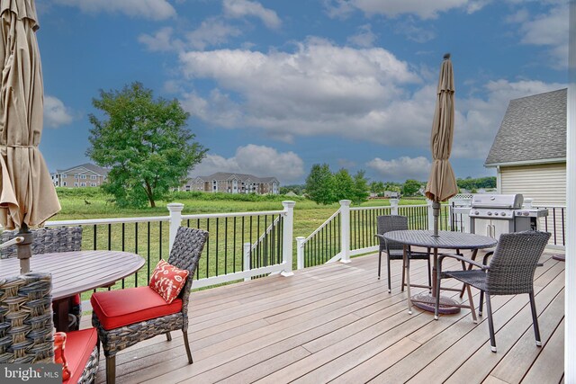 wooden terrace featuring a lawn and grilling area