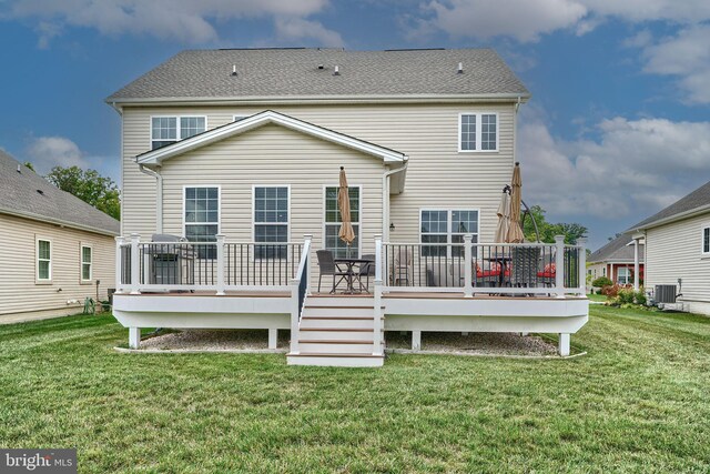 back of property featuring a yard, a wooden deck, and central AC