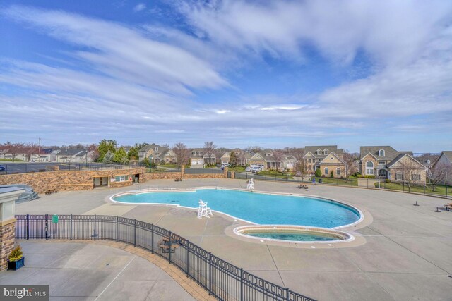 view of swimming pool featuring a community hot tub and a patio area