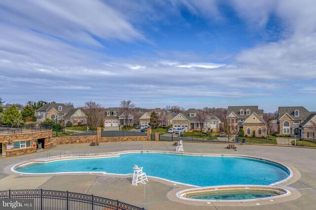 view of pool with a hot tub and a patio area