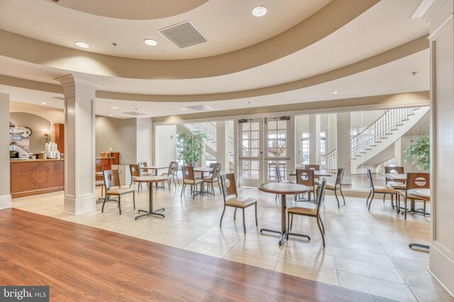 interior space featuring a tray ceiling and ornate columns