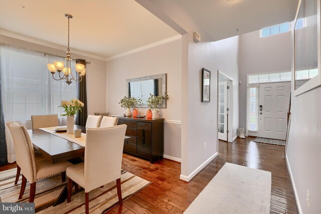 dining room with crown molding, dark wood-type flooring, and a chandelier