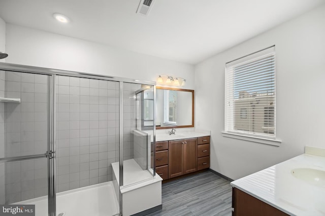 bathroom with vanity, an enclosed shower, and hardwood / wood-style floors