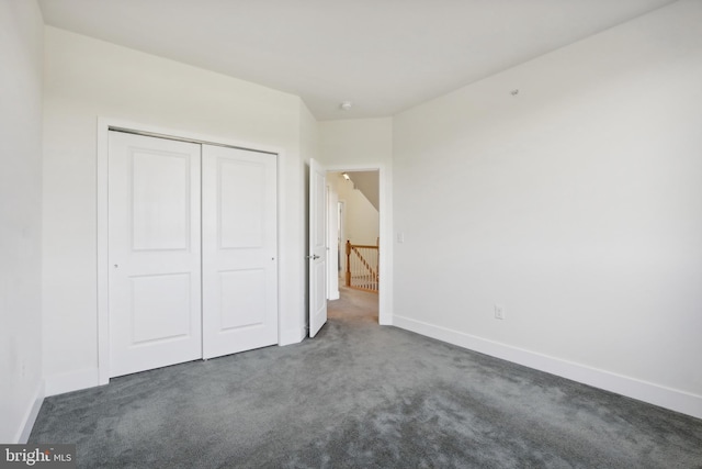 unfurnished bedroom with a closet and dark colored carpet