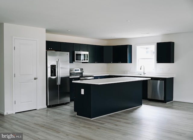 kitchen with a center island, light hardwood / wood-style floors, and appliances with stainless steel finishes