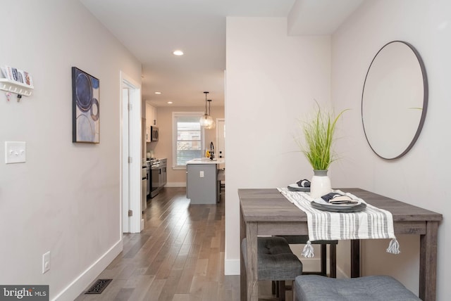 dining space featuring sink and hardwood / wood-style floors