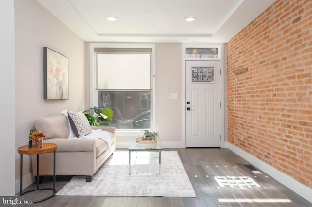 interior space featuring hardwood / wood-style flooring and brick wall