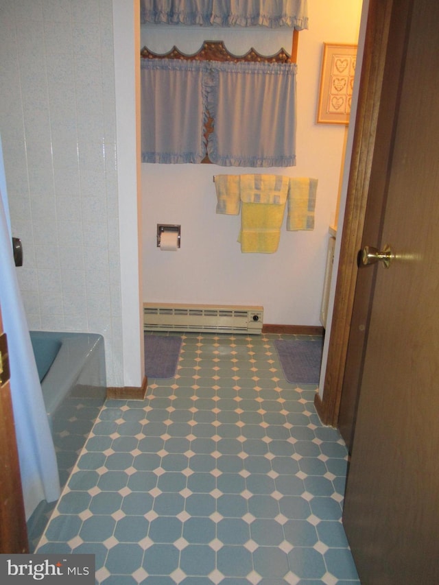 bathroom with a tub and a baseboard radiator