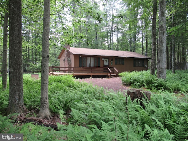 rear view of house featuring a wooden deck