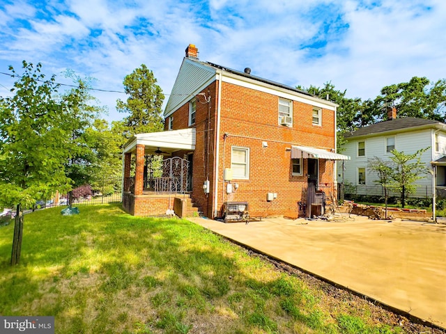 rear view of house featuring cooling unit, a patio, and a lawn