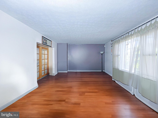 unfurnished room featuring a textured ceiling and hardwood / wood-style floors