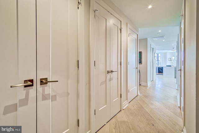 corridor with light hardwood / wood-style floors