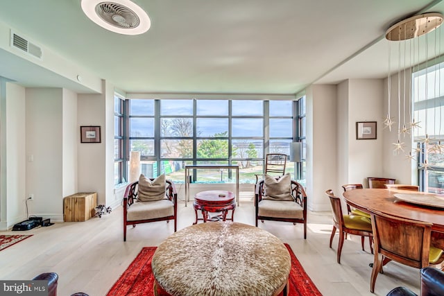 living area with expansive windows and light hardwood / wood-style floors