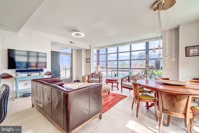 living room featuring light hardwood / wood-style flooring and a wall of windows